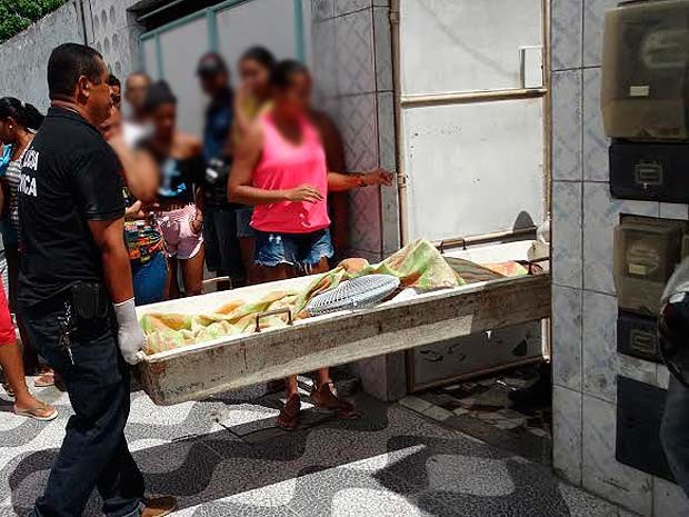 Agentes do departamento técnico retirando o corpo da jovem de dentro da casa, em Feira de Santana (Foto: Ney Silva/Acorda Cidade)