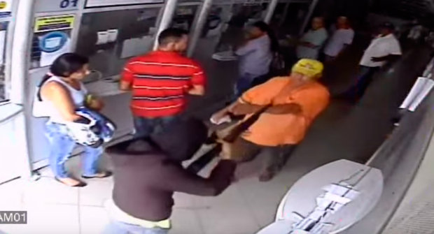 Nas imagens é possível ver o homem ignorando a arma apontada para ele e saindo da lotérica
