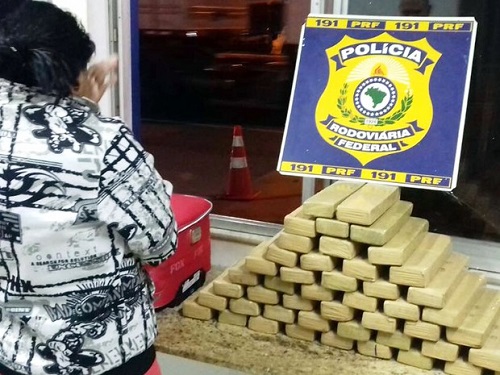 Mulher foi presa ao transportar 42 kg de drogas dentro de mala em ônibus (Foto: Divulgação/PRF)