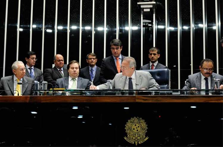 O presidente do Senado, Renan Calheiros (C), ao lado do deputado Rodrigo Maia, presidente da Câmara, promulga a PEC do Teto