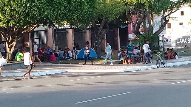 O grupo se aglomerou em frente à escola e passou a noite no local para garantir um lugar na fila e conseguir efetuar a matrícula na escola de preferência (Foto: Camaçari Fatos e Fotos) O grupo se aglomerou em frente à escola e passou a noite no local para garantir um lugar na fila e conseguir efetuar a matrícula na escola de preferência (Foto: Camaçari Fatos e Fotos)