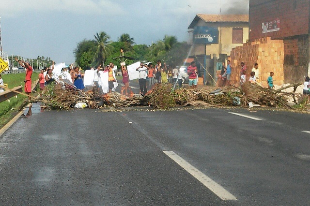 Os moradores interditaram a via queimando pneus e podas de árvore (Foto: Saadia Souza) Os moradores interditaram a via queimando pneus e podas de árvore (Foto: Saadia Souza)