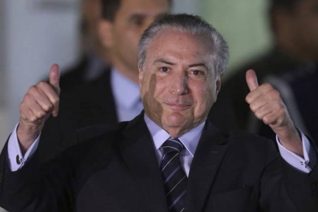 Planalto inicia demissões de apadrinhados de deputados que votaram a favor do processo contra Temer (Foto: Eraldo Peres/AP) Planalto inicia demissões de apadrinhados de deputados que votaram a favor do processo contra Temer (Foto: Eraldo Peres/AP)