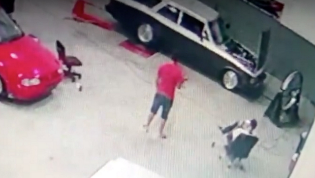 Câmeras de segurança da oficina flagraram o momento em que a peça se desprendeu do carro e atingiu o mecânico (Foto: Reprodução | Record TV)