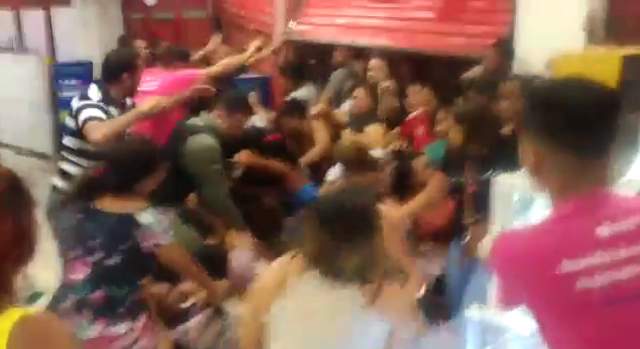 Mulher que grava o vídeo de dentro duma loja, grita desesperadamente 'calma gente' (Foto: Print | Vídeo)