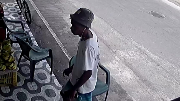 Jovem se passa por cliente e pega alguns produtos para se dirigir ao caixa e então anuncia o assalto (Foto: Reprodução)