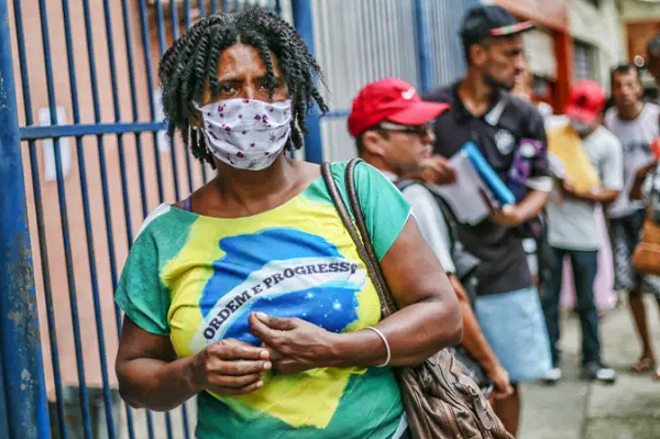 Pessoas de máscara aguardam em fila no Rio de Janeiro (Foto: Andre Coelho | Bloomberg | Getty Images)