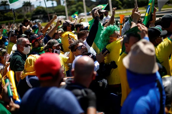 Fotógrafo do Estadão Dida Sampaio é um empurrado por um dos manifestantes da escada que usava para registrar as imagens do presidente Jair Bolsonaro; fotógrafo relata que recebeu o empurrão na altura da cintura, do lado direito. Dida, que bateu a cabeça ao cair no chão, continuou sendo hostilizado pelos manifestantes, mas um grupo o ajudou a se levantar (Foto: Ueslei Marcelino | Reuters) Fotógrafo do Estadão Dida Sampaio é um empurrado por um dos manifestantes da escada que usava para registrar as imagens do presidente Jair Bolsonaro; fotógrafo relata que recebeu o empurrão na altura da cintura, do lado direito. Dida, que bateu a cabeça ao cair no chão, continuou sendo hostilizado pelos manifestantes, mas um grupo o ajudou a se levantar (Foto: Ueslei Marcelino | Reuters)