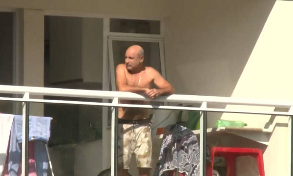 Queiroz pega sol na sacada do apartamento onde cumpre prisão domiciliar, no Rio (Foto: Reprodução | Agência O Globo)