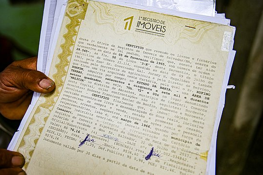 Parente exibe prova que o loteamento faz parte de áera da família (Foto: Tiago Caldas | Correio) 