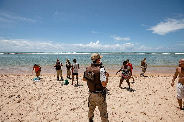 Policiais militares orientam os banhistas sobre a interdição das praias no litoral de Camaçari neste domingo, 21 (Foto: Tiago Pacheco)