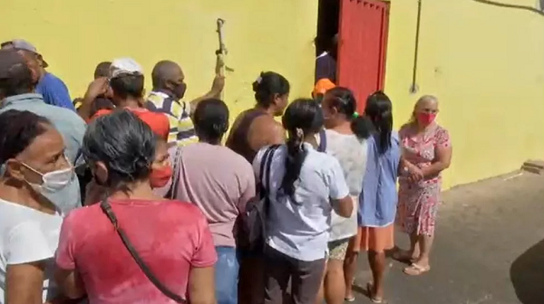 Fila em frente açougue para doação de ossos em Cuiabá (Foto: TV Centro América)