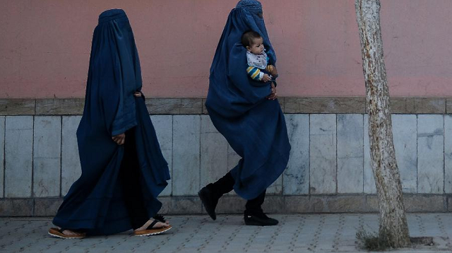 Mulheres afegãs vestidas de burca caminham ao longo de uma trilha em Cabul (Foto: Hoshang Hashimi/AFP)