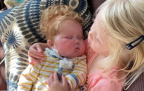 Ivy Sinnamon segura seu irmão, Easton, que precisava de um transplante de coração devido a uma doença congênita (Foto: Arquivo/ Duke University)
