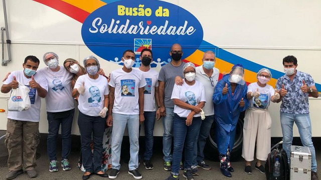 Voluntários da Cidade da Luz participam do Busão da Solidariedade, iniciativa que percorre as ruas de Salvador oferecendo gratuitamente banho e alimentação para públicos vulneráveis (Foto: Divulgação)