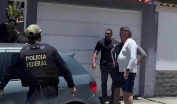Jair Bolsonaro com policiais federais na porta da casa de Angra dos Reis, esta manhã (Foto: GloboNews/Reprodução)