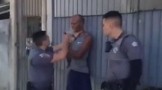 Instante em que o PM descarrega o spray de pimenta no rosto do homem (Foto: Reprodução/X)