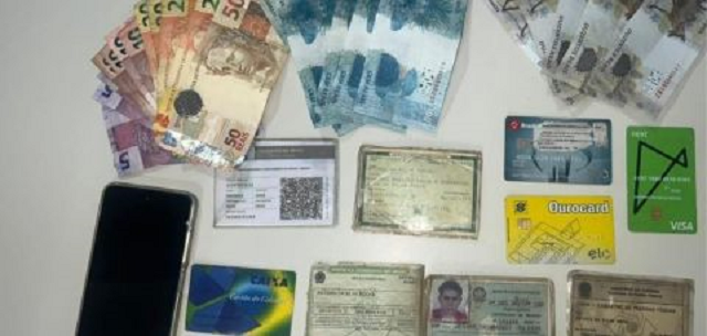 Durante a busca pessoal, foram encontradas notas falsas, documentos, celular e dinheiro (Foto: Divulgação/SSP)