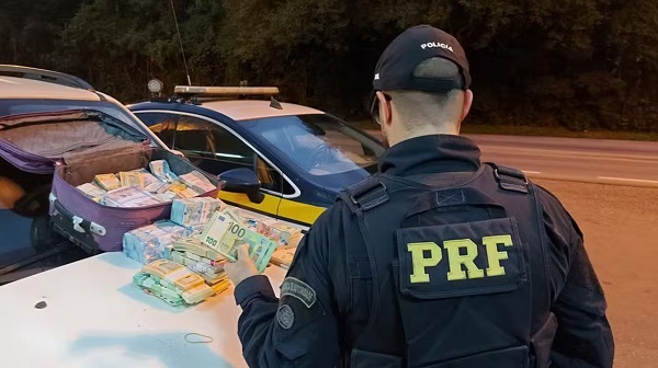 PRF encontrou maços de cédulas de reais, dólares e euros escondidos em malas e no compartimento do estepe do veículo (Reprodução/PRF)