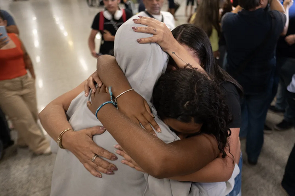 Um homem deportado dos EUA é recebido por parentes no Aeroporto Internacional de Confins, em Confins, estado de Minas Gerais (Foto: DOUGLAS MAGNUM AFP)