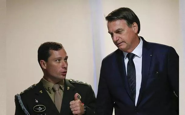 Coronel, ex-ajudante de ordens expressa frustração com disparidade financeira entre ele e o ex-presidente - Mauro Cid (à esq.) e Jair Bolsonaro. Foto: Reuters