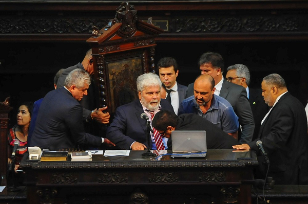 O deputado Wagner Montes é carregado para a cadeira da presidência da Alerj. Ele presidiu a sessão que livrou os deputados Jorge Picciani, Edson Albertassi e Paulo Melo da prisão determinada pela Justiça na operação Cadeira Velha (Foto: Luiz Ackermann | Agência O Dia | Estadão Conteúdo) O deputado Wagner Montes é carregado para a cadeira da presidência da Alerj. Ele presidiu a sessão que livrou os deputados Jorge Picciani, Edson Albertassi e Paulo Melo da prisão determinada pela Justiça na operação Cadeira Velha (Foto: Luiz Ackermann | Agência O Dia | Estadão Conteúdo)