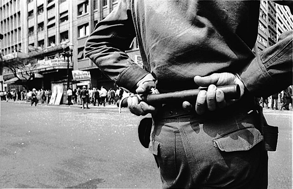 Policial observa manifestação do Movimento Estudantil contra a censura imposta pela ditadura militar, meses antes da aprovação do Ato Institucional nº 5, que concedia poderes absolutos ao presidente durante o regime militar (Foto: Arquivo | Estadão Conteúdo) Policial observa manifestação do Movimento Estudantil contra a censura imposta pela ditadura militar, meses antes da aprovação do Ato Institucional nº 5, que concedia poderes absolutos ao presidente durante o regime militar (Foto: Arquivo | Estadão Conteúdo)