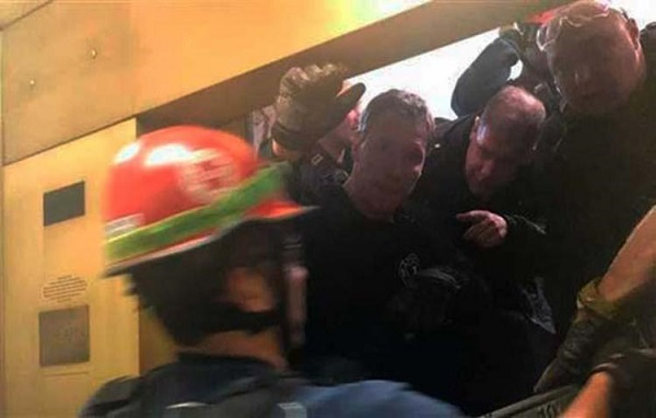 Bombeiros tiveram de fazer um buraco na parede do edifício para chegar até as pessoas (Foto: Divulgação)