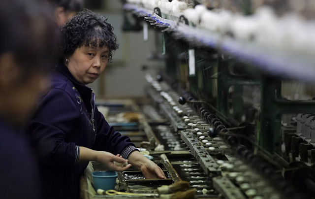 Mulher trabalha em fábrica de seda na província chinesa de Jiangsu (Foto: Andy Wong | AP) Mulher trabalha em fábrica de seda na província chinesa de Jiangsu (Foto: Andy Wong | AP)
