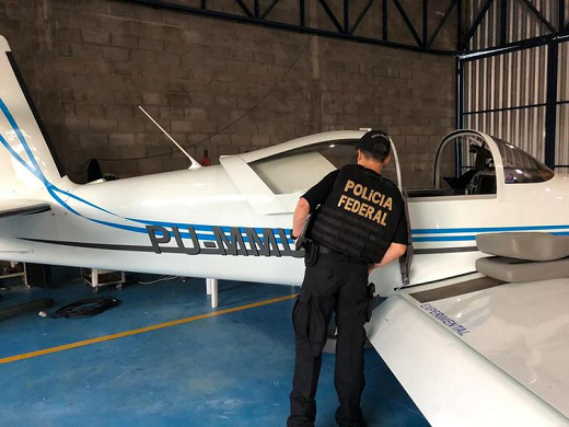 Policial observa aeronave apreendida durante operação Flak (Foto: Polícia Federal | Divulgação)