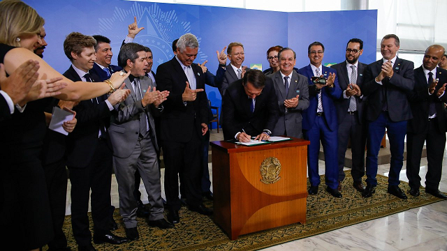 Presidente da República, Jair Bolsonaro assina o Decreto que dispõe sobre a aquisição, o cadastro, o registro, a posse, o porte e a comercialização de armas (Foto: Carolina Antunes | PR)