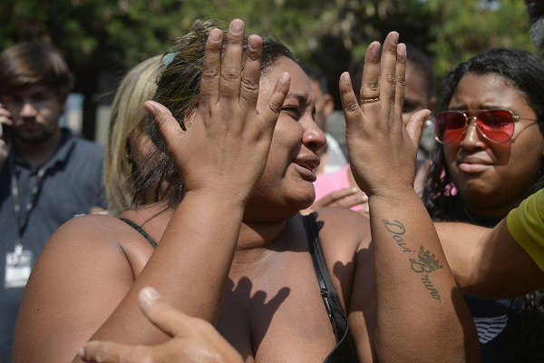 Luciana chegou ao IML amparada por parentes e amigos. Ela contou que ainda não teve coragem de contar ao filho que o pai morreu (Foto: Reprodução) Luciana chegou ao IML amparada por parentes e amigos. Ela contou que ainda não teve coragem de contar ao filho que o pai morreu (Foto: Reprodução)