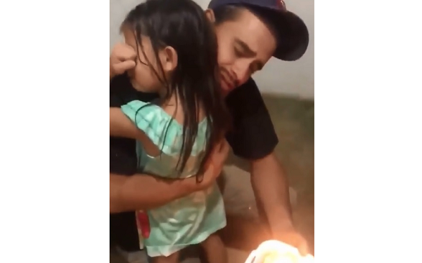 Pequena Emanuelly de cinco anos chora ao receber de seu pai um presente: uma fatia de bolo de aniversário (Foto: Reprodução)