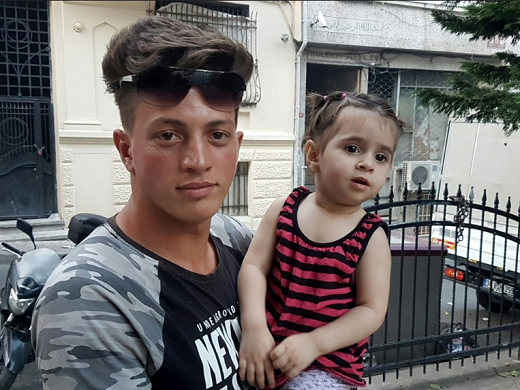 O argelino Fawzi Zabaat e a menina síria que salvou (Foto: DHA | AFP)
